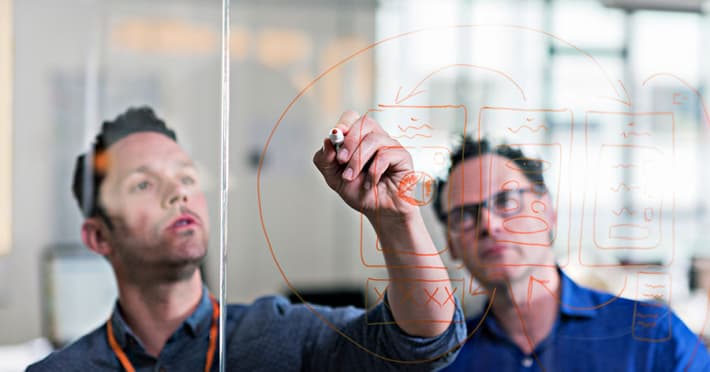 Colleagues brainstorming at the drawing board