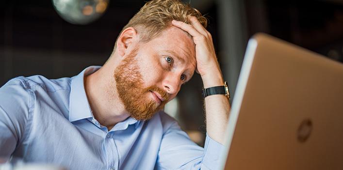 Worried man looking at a laptop screen.