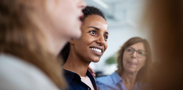 Group of colleagues, woman in the centre is smiling