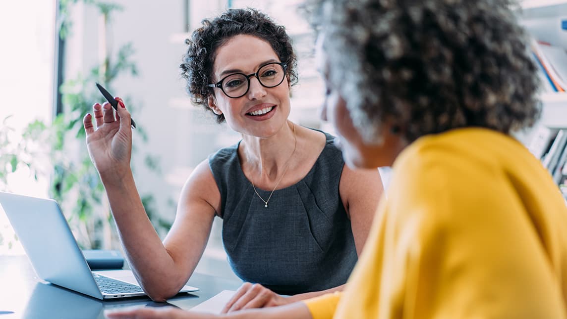 Two colleagues collaborate at a computer.