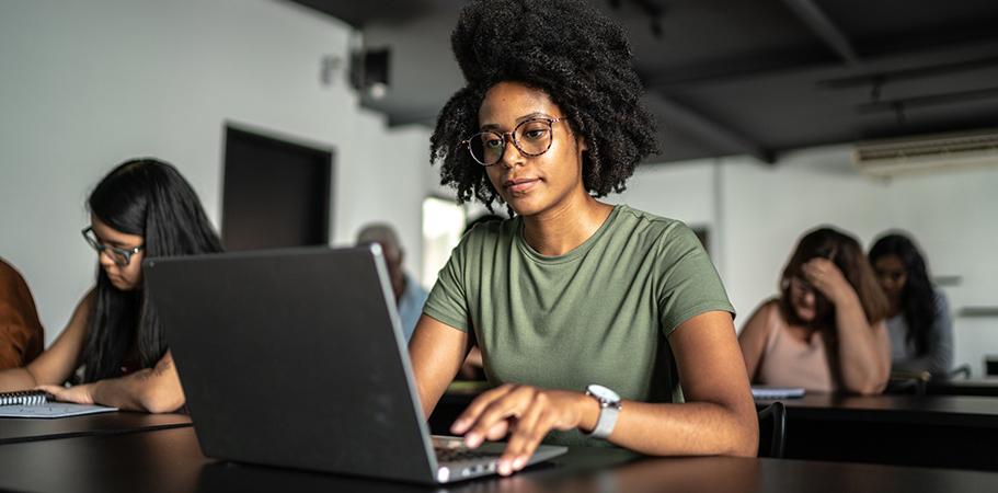 A female student sitting with a laptop.